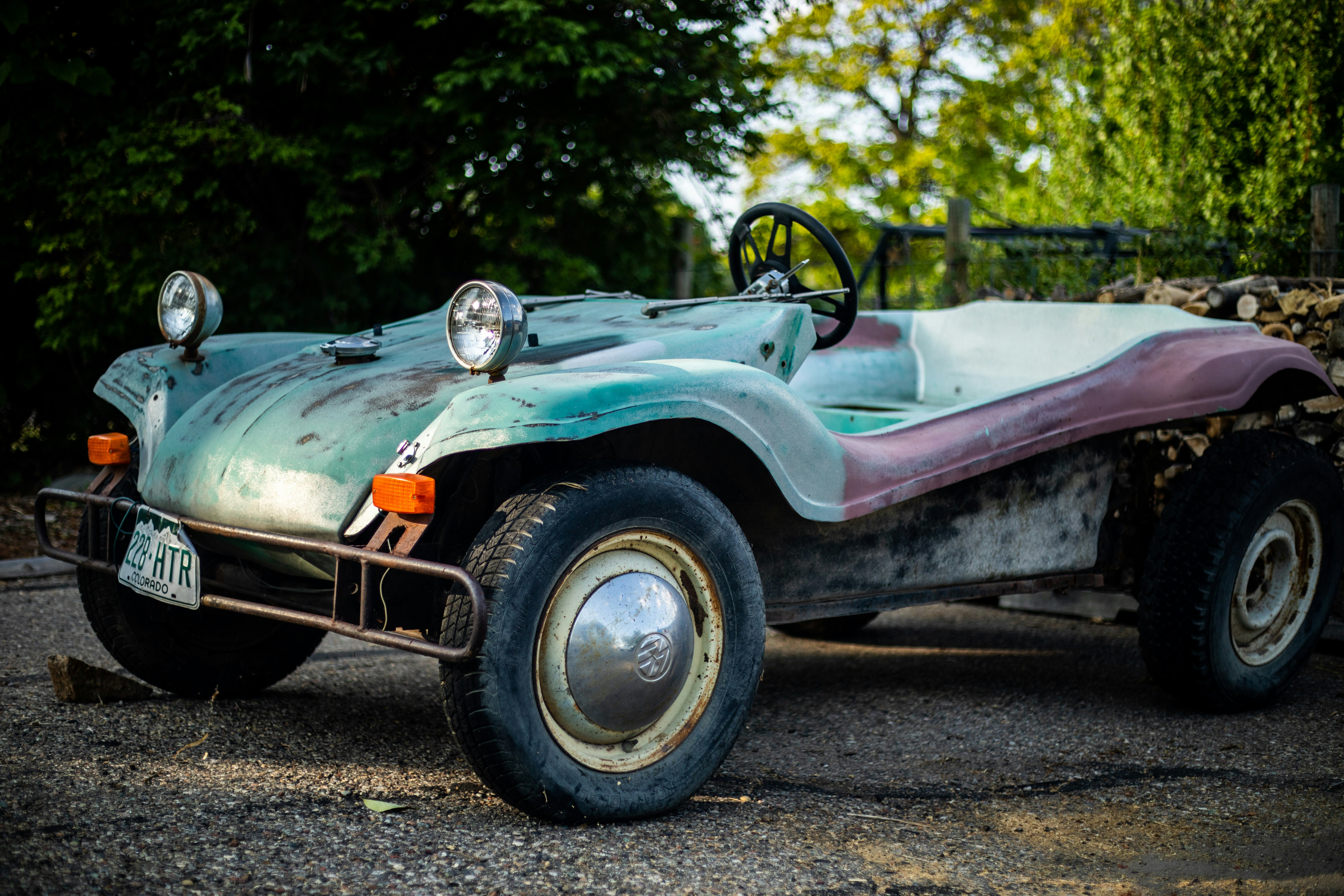 white and pink vintage car on road during daytime